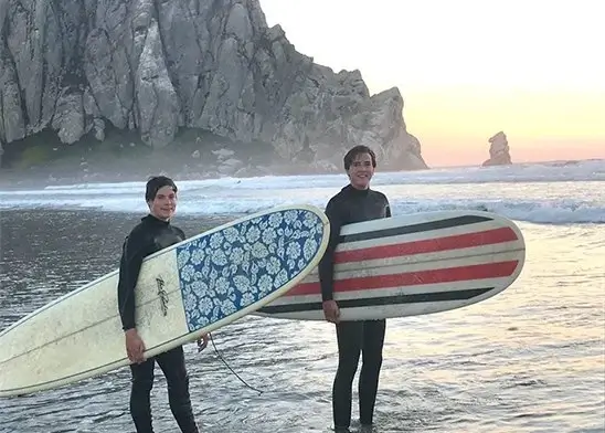 chicos con tablas de surf en playa de canada